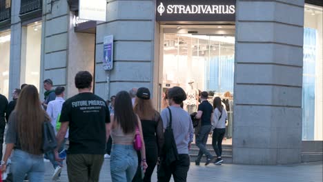 Pedestrians-walk-past-the-Spanish-women's-clothing-fashion-brand-from-Spain-owned-by-the-Inditex-group,-Stradivarius,-store-during-nighttime