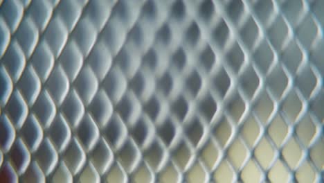A-hyper-macro-shot-of-a-metal-grid,-steel-pattern,-iron-industrial-texture,-aluminum-material,-super-slow-motion,-Full-HD-120-fps,-smooth-zoom-out-movement,-blurry-Depth-Of-Field
