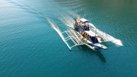 drone-flight-over-a-tourist-boat-around-Coron,-Palawan,-Philippines