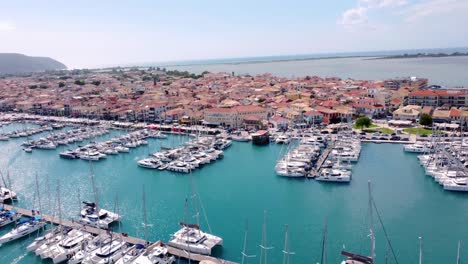 Aerial-drone-video-of-famous-marina-of-Lefkada-island-town-with-anchored-yachts-and-sail-boats,-Ionian,-Greece