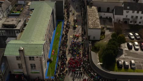 Aerial-ascend-as-seagulls-soar-in-sky-above-Galway-Ireland-festive-parade-on-sunny-day