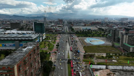 Drone-flying-over-traffic-on-the-NQS-avenue-in-partly-sunny-Bogota,-Colombia