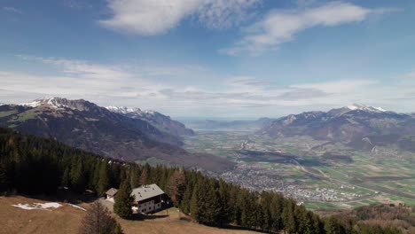 Beautiful-drone-panorama-of-a-Swiss-Chalet-looking-down-on-lush-valley-in-the-Alps