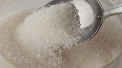 A-spoon-scooping-sugar-out-of-a-plastic-container
