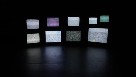 Una-Pared-De-Televisores-Catódicos-Antiguos-Y-Variados-En-Una-Habitación-Oscura-Y-Aislada