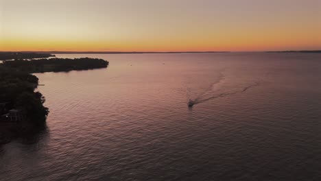 Filmische-Luftaufnahme-Eines-Bootes,-Das-Bei-Sonnenuntergang-Auf-Dem-Paraná-Fluss-Segelt