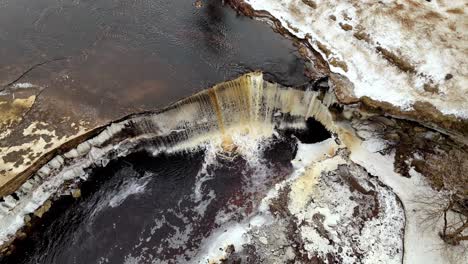 Luftaufnahme-Von-Oben-Auf-Estlands-Jägala-Wasserfall,-Jägala-Fluss,-Winterschnee,-Eisweiße-Malerische-Landschaft