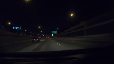 Series-number-seven-hyperlapse-showing-car-driving-through-downtown-Dallas-Texas-at-night-with-city-lights,-interstate-driving,-and-going-under-many-overpasses