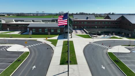Aerial-approaching-shot-of-Conestoga-Valley-School-with-american-Flag-at-sunny-day