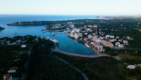 Aerial-view-of-Portopetro,-Mallorca-at-dusk-with-serene-water-and-buildings