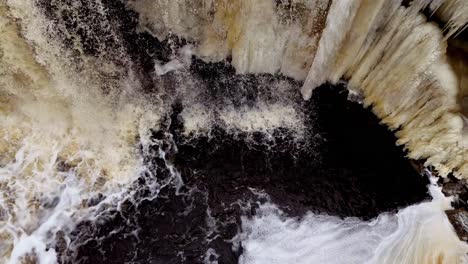 drone-flowing-water-falling-from-hight-altitude-waterfall-in-Estonia