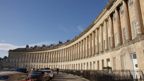 Hombre-Caminando-Delante-De-Las-Casas-Del-Circo-En-Bath,-Somerset,-Inglaterra,-Reino-Unido.