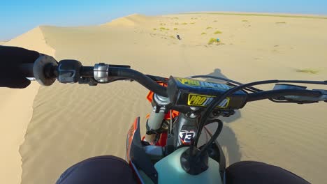 Dirt-biking,-motocross,-sandy-dunes,-sparse-vegetation,-UAE,-Liwa-desert