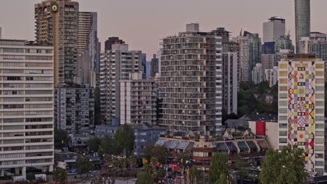 Vancouver,-BC,-Kanada,-Luftaufnahme-Eines-V64-Zoom-Drohnenüberflugs-über-English-Bay-Beach,-Aufnahme-Der-Stadtlandschaft-Des-West-Ends,-Hoch-Aufragender-Wohngebäude-Mit-Bergkulisse-In-Der-Abenddämmerung-–-Aufgenommen-Mit-Mavic-3-Pro-Cine-–-Juli-2023