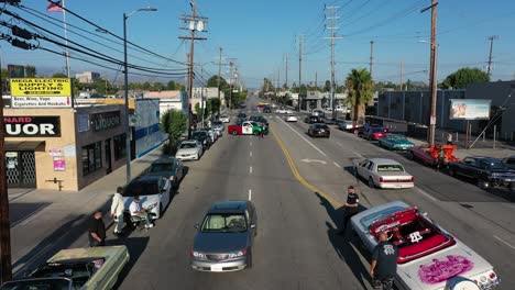 Cars-drive-down-road---car-show