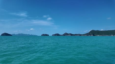 Amplia-Vista-Del-Agua-Azul-Y-Verde-Del-Océano-Con-Hermosos-Monumentos-Rocosos-En-El-Fondo