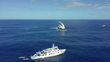 Weißes-Tauchboot-In-Der-Nähe-Der-Mit-Guano-Bedeckten-Felseninsel-Roca-Partida-Im-Pazifik,-Luftaufnahme