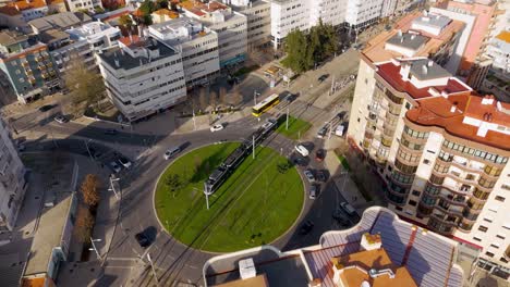 Tram-and-road-traffic-on-a-roundabout-in-Almada,-Portugal