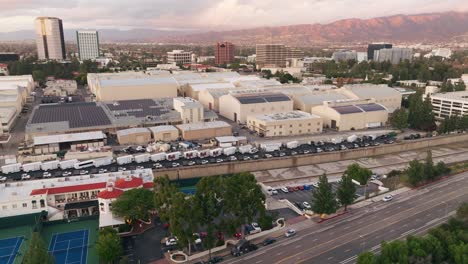 Aerial-Drone-Footage-Over-Warner-Brothers-Studio-Backlot-With-Sunlit-Mountains-on-Horizon