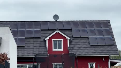 Moderne-Sonnenkollektoren-Auf-Dem-Dach-Eines-Modernen-Roten-Holzhauses