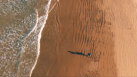 Aerial-of-man-running-on-La-Jolla-beach-in-San-Diego