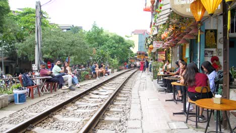 Turistas-Y-Lugareños-Sentados-En-La-Ubicación-De-La-Calle-Del-Tren-De-Hanoi
