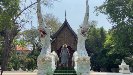 Turista-Con-Sombrero-Caminando-En-El-Templo-Tailandés,-Chiang-Mai