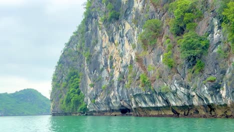 Ha-Long-and-Lan-Ha-Bay-area,-Vietnam-cruising-in-a-sampan-past-giant-limestone-karsts-in-emerald-waters
