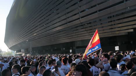 Ein-Fan-Hält-Eine-Spanische-Flagge-Mit-Einem-Real-Madrid-Emblem,-Während-Eine-Große-Menschenmenge-Das-Champions-League-Fußballspiel-Der-Spanischen-Und-Britischen-Mannschaften-Real-Madrid-Und-Manchester-City-Im-Santiago-Bernabéu-Stadion-Besucht