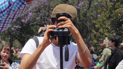 Latin-man-taking-a-photo-of-the-solar-eclipse-from-a-reflex-camera-on-a-tripod,-Mexico-April-8,-2024