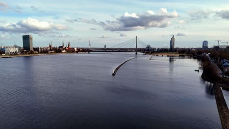 Luftaufnahme-Des-Flusses-Daugava-Mit-Der-Vansu-Brücke-In-Der-Ferne-In-Riga,-Lettland