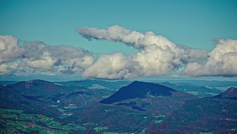 Nubes-Blancas-Y-Esponjosas-Ruedan-Y-Se-Curvan-En-El-Cielo-Sobre-Picos-Montañosos-Escarpados-En-El-Campo