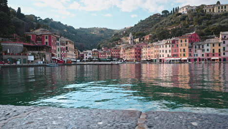 Vista-Deslizante-Sobre-El-Agua-De-Coloridas-Casas-De-Colores-Pastel-En-El-Paseo-Marítimo-De-Portofino