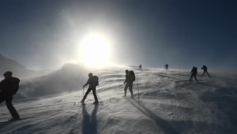 Skiers-skiing-down-mountain-through-spring-blizzard,-Voss,-Norway