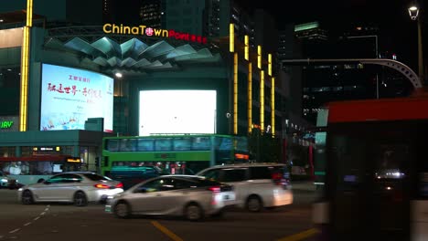 Busy-night-traffics-at-the-junction-of-Eu-Tong-Sen-street,-New-Bridge-Road-and-Upper-Cross-street-featuring-landmark-Chinatown-Point-shopping-mall-at-downtown-Singapore,-static-shot