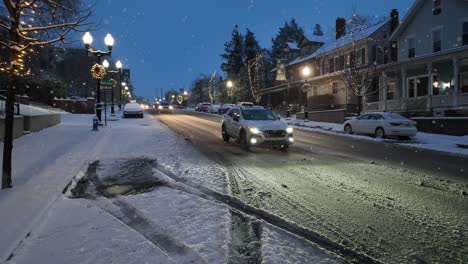 Snow-flurries-falling-on-main-street-in-small-town-during-blue-hour
