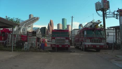 Toma-De-Escena-De-Un-Patio-Lleno-De-Camiones-De-Bomberos-Discapacitados-Con-El-Centro-De-Houston-Al-Fondo