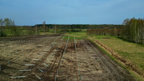 Instalación-De-Postes,-Montaje-De-Un-Sistema-De-Energía-De-Paneles-Solares:-Revelación-Aérea-De-Retroceso.