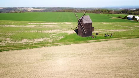 Nove-Dvory,-Bilovec,-Distrito-De-Nove-Jičín,-República-Checa---Visitantes-Descubriendo-El-Antiguo-Molino-De-Viento-En-Medio-Del-Tranquilo-Paisaje-Rural---Drones-Volando-Hacia-Adelante