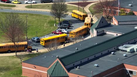 Yellow-school-bus-parking-at-high-school-in-spring