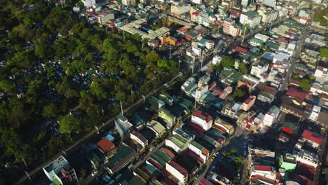 AERIAL:-Olympia,-south-cemetery-and-the-Santa-Cruz-Barangay,-sunny-afternoon-in-Makati,-Philippines