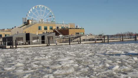 Harbour-pool-and-saunas-with-Sky-Wheel-behind,-icy-Baltic-Helsinki