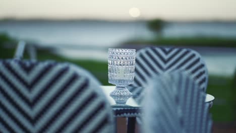 Table-with-a-centerpiece-of-a-candle-in-a-glass-vase-and-chairs-with-zigzag-patterns