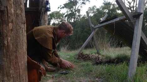 Un-Hombre-Australiano-Iniciando-Fuego-Con-Un-Pedernal-Y-Acero-En-Una-Histórica-Cabaña-De-Corteza