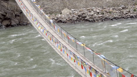 Puente-Colgante-Tibetano-Decorado-Con-Banderas-De-Oración-Multicolores-Cerca-Del-Pueblo-De-Montaña-De-Sichuan-En-China
