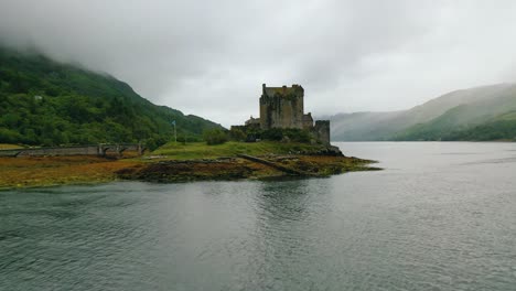 Drone-view-of-Eilean-Donan-Castle-during-low-level-flight-over-Loch-Duich-on-low-tide