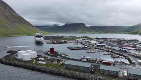 Isafjordur,-Iceland,-Aerial-View-of-Town-Port,-Buildings,-Cruise-Ship-and-Fjord,-Drone-Shot
