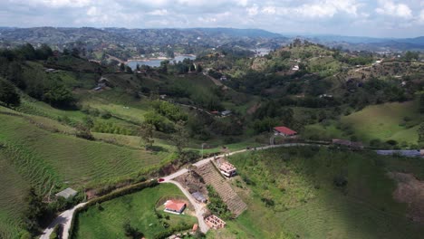 Aerial-View,-Drone-Shot,-Landscape-of-Guatape-Region,-Colombia,-Green-Hills,-Village-Homes-and-Lake