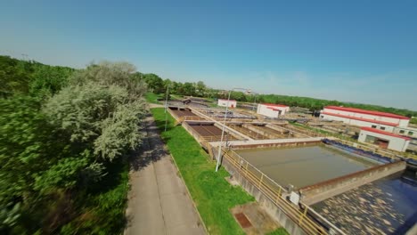 Vuelo-Bajo-Sobre-Una-Planta-De-Tratamiento-De-Agua-Industrial-En-Un-Día-Soleado---Imágenes-De-Drones-FPV-