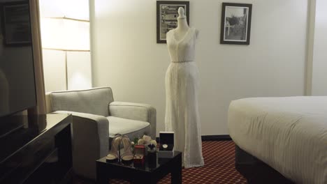 Un-Vestido-De-Novia-Blanco-Se-Muestra-En-Un-Maniquí-En-Una-Habitación-De-Hotel.